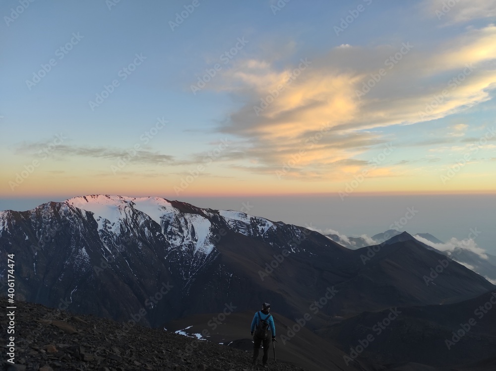 Sunset and clouds behind the snowy mountains of Caucasus shot from the mountain Sunset and clouds behind the snowy mountains of Caucasus shot from the mountain