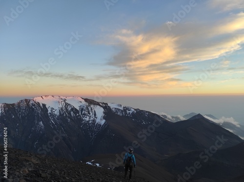 Sunset and clouds behind the snowy mountains of Caucasus shot from the mountain