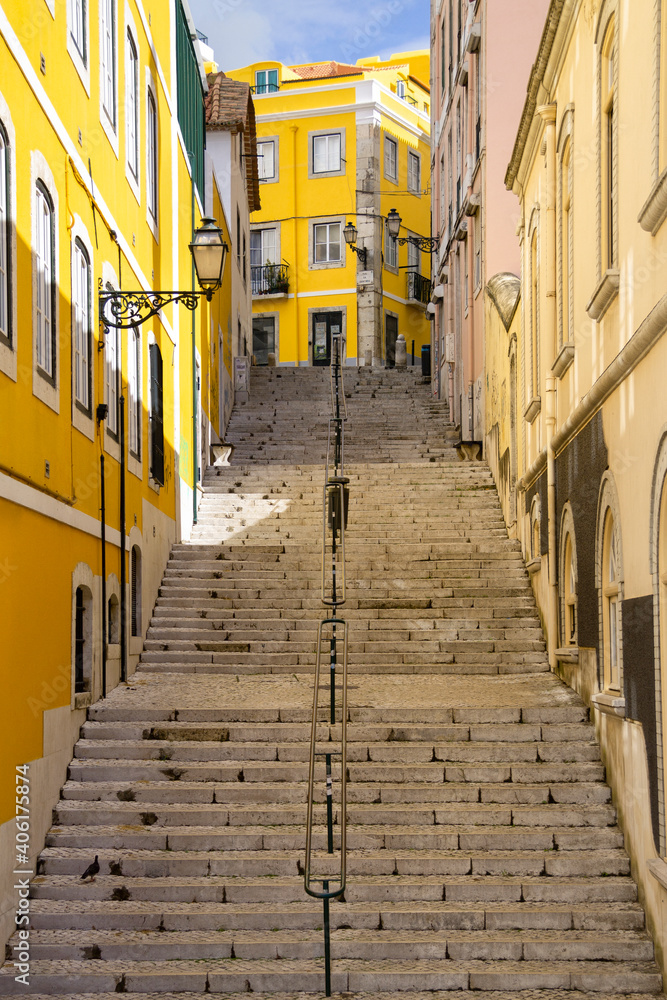 Typical steep street with long stairs and colorful walls of the city of Lisbon, Portugal. 