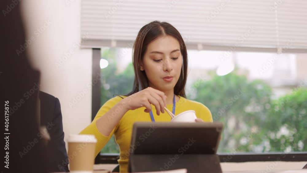 Asian freelancer woman eats instant noodles and speaks on smart phone to work at home in the evening.Hungry young Asia girl sitting and work at home concept. Asian freelancer woman eats instant noodles and speaks on smart phone to work at home in the evening.Hungry young Asia girl sitting and work at home concept.
