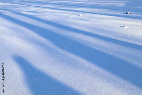 Gradient structure of falling shadow on white snow of lake 