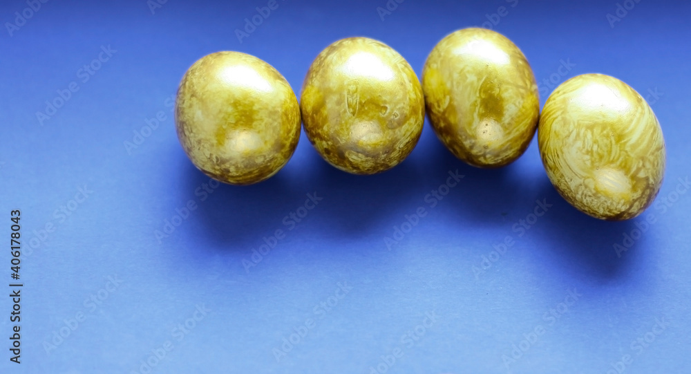 Top view easter composition. Easter greeting card with golden eggs on a blue background, copy space. Top view easter composition. Easter greeting card with golden eggs on a blue background, copy space.