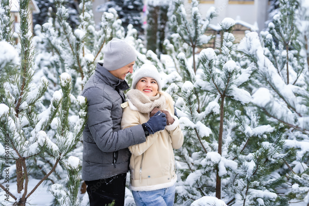 happy loving couple walking in snowy winter forest, spending christmas vacation together. Outdoor seasonal activities. Lifestyle happy loving couple walking in snowy winter forest, spending christmas vacation together. Outdoor seasonal activities. Lifestyle