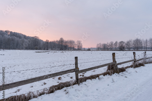 Zaun im Winter auf Weide im Schnee vor Wald bie Sonnenuntergang © H. Rambold