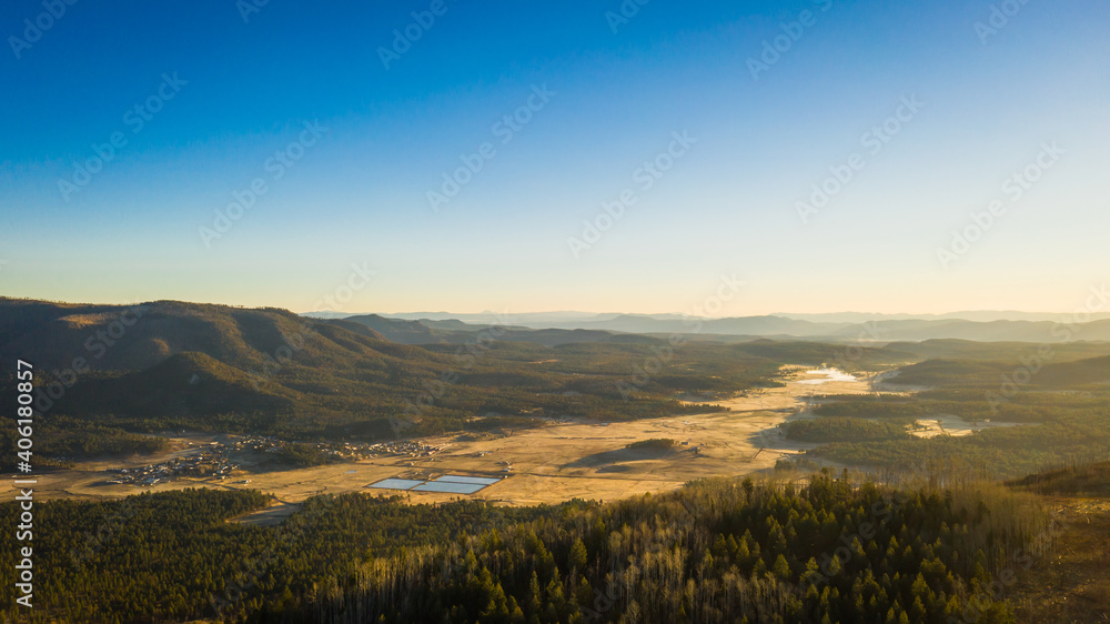 An aerial image of a mountain valley in the early morning light.