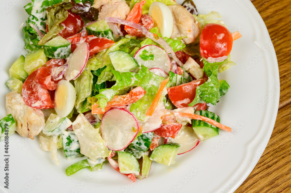 Vegetable vegetarian salad with tomatoes, peppers and onions on wooden table.