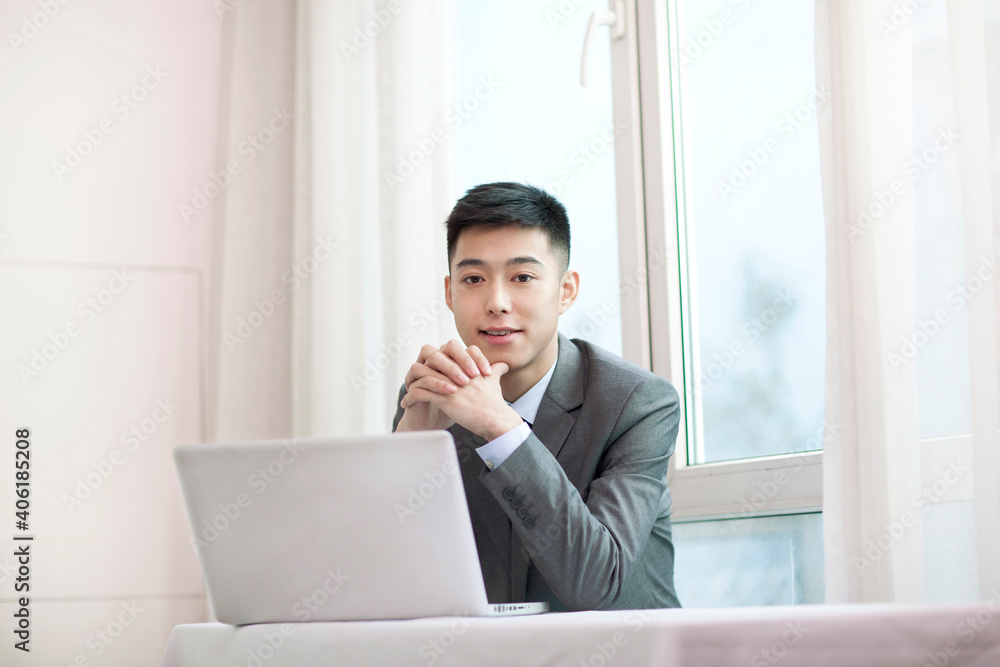 Portrait of young bisinessman sitting in the front of laptop Portrait of young bisinessman sitting in the front of laptop