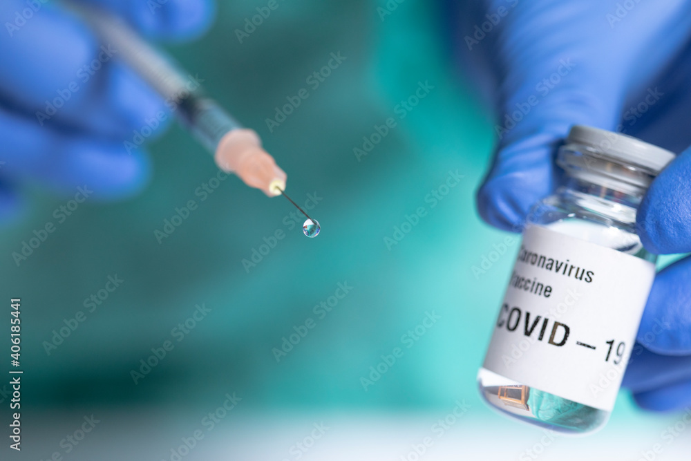 Close up of syringe with a vaccine drop. Focus on drop.