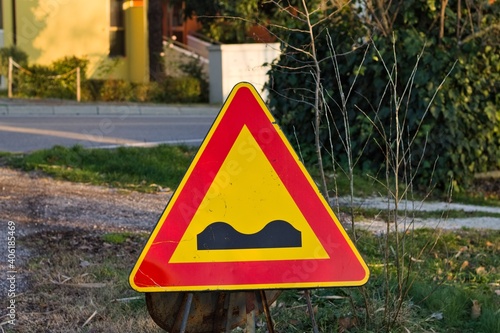 A triangular road sign of work in progress indicating the presence of bumps (Marche, Italy, Europe)
