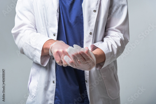Closeup of a doctor's hands in medical clothing who puts gloves on his hands. Health and protection concept
