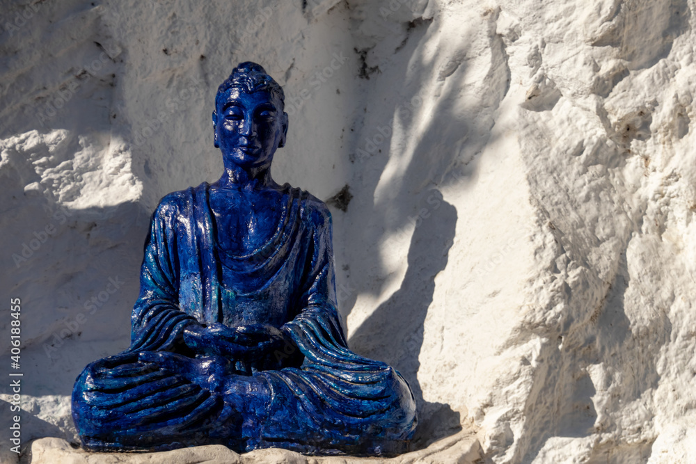 Figura azul de budista meditando en la postura de loto Figura azul de budista meditando en la postura de loto