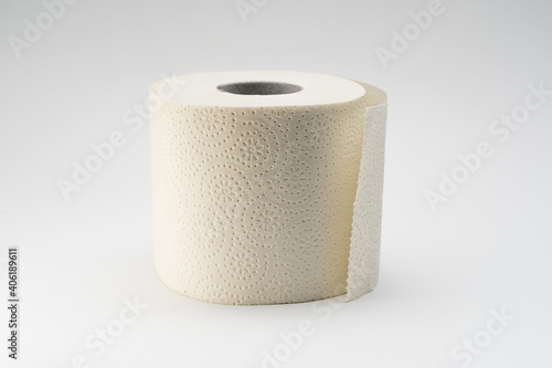 White toilet paper roll on a neutral white background. Full bathroom tissue out of recycled material.