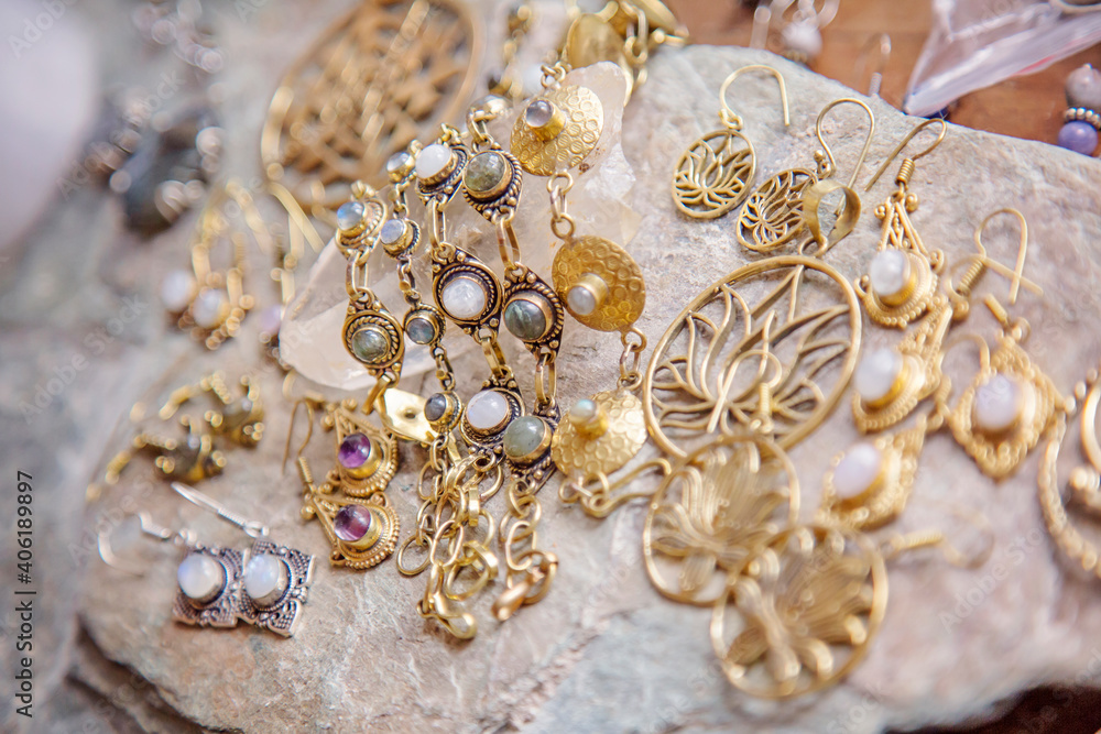 Brass jewelry with natural mineral gemstones on natural rocky background Brass jewelry with natural mineral gemstones on natural rocky background