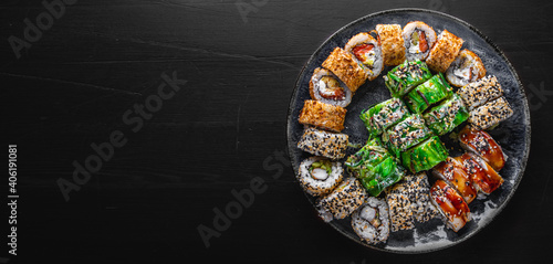 set of sushi roll with salmon, avocado, cream cheese, cucumber, rice, tuna in plate on black background