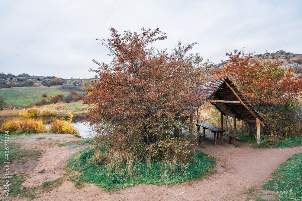 Small wooden gazebo among beautiful autumn trees on the Carpathian hills in Ukraine