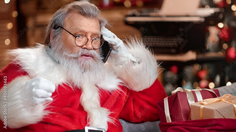 Man in Santa Claus costume having conversation on mobile. Medium close up shot on 4k RED camera Man in Santa Claus costume having conversation on mobile. Medium close up shot on 4k RED camera