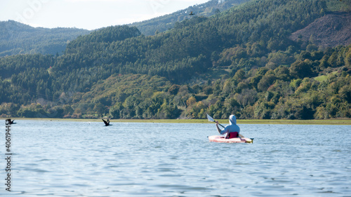 Hombre joven remando en piragua en una ría photo