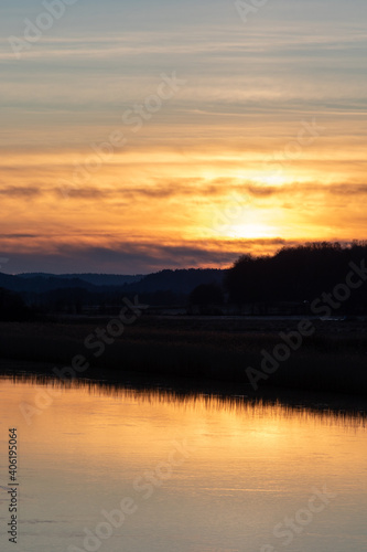 Sunset over Gota river in western Sweden. Treeline is reflecting in the water © Andreas Bergerstedt