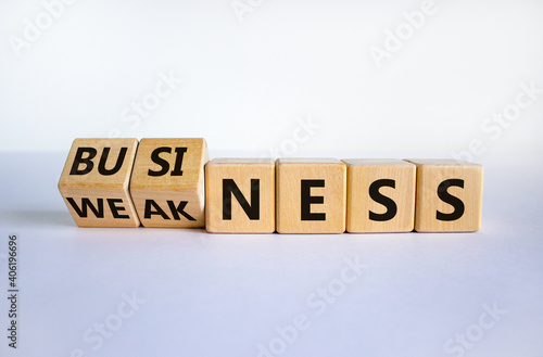 Business or weakness symbol. Turned wooden cubes and changed the word 'weakness' to 'business'. Beautiful white background, copy space. Business or weakness concept.