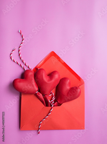 happy valentines day.postcard message of love. red envelope with three red heart-shaped balloons on a pink background