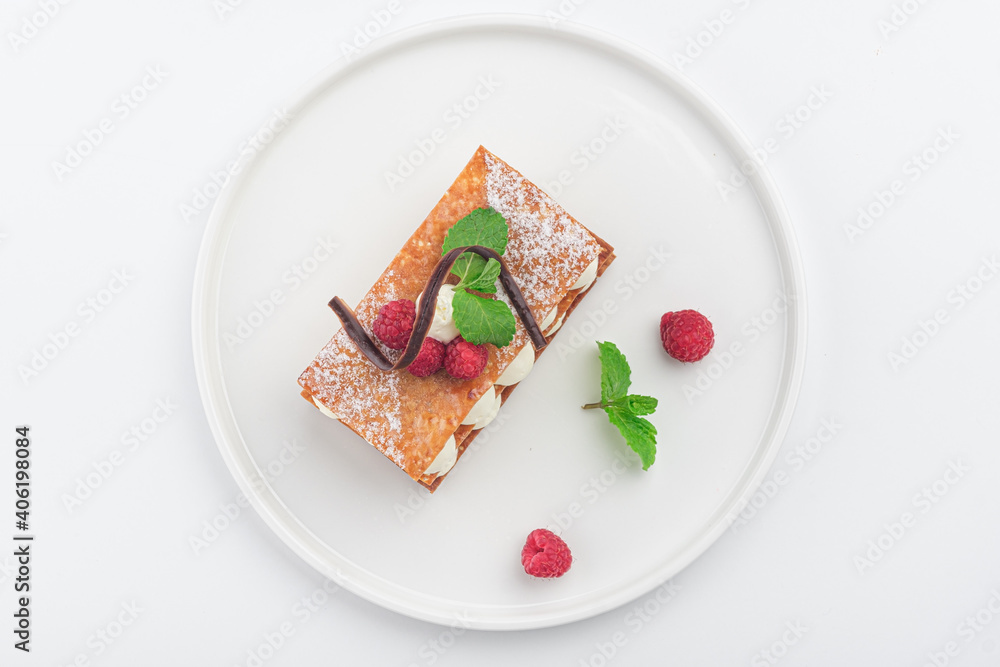 raspberry mille feuille dessert on a white plate, top view raspberry mille feuille dessert on a white plate, top view