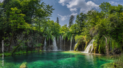 Fototapeta Naklejka Na Ścianę i Meble -  Amazing panorama with waterfall, water coming down from lichens to turquoise coloured lake. Plitvice Lakes National Park UNESCO World Heritage Croatia