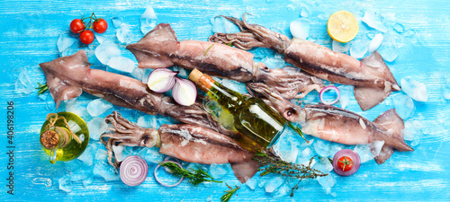 Sea squid on ice on a blue wooden background. Seafood. On a dark background.