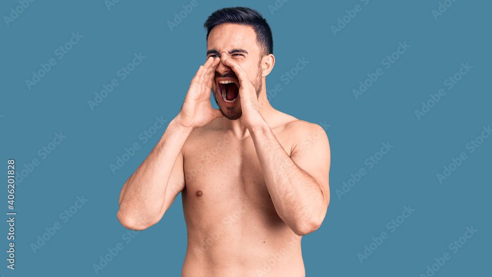 Fototapeta premium Young handsome man wearing swimwear shouting angry out loud with hands over mouth