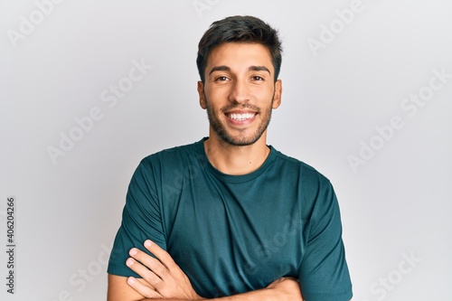 Young handsome man wearing casual clothes happy face smiling with crossed arms looking at the camera. positive person.