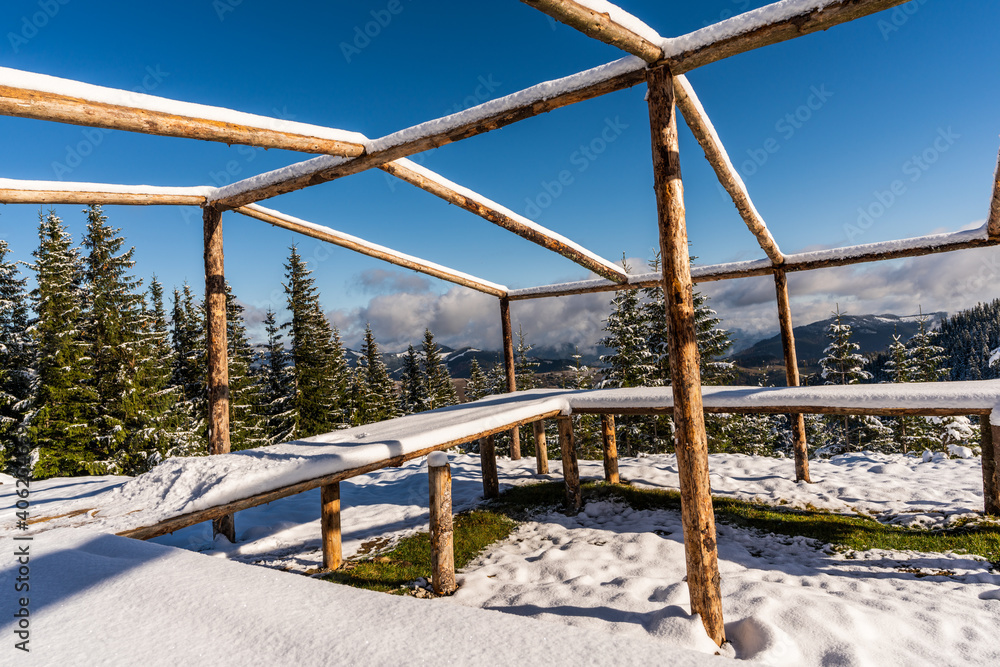 The gazebo on the top of the mountain stands in a snow-covered meadow, bathed in the light of the bright cold sun The gazebo on the top of the mountain stands in a snow-covered meadow, bathed in the light of the bright cold sun