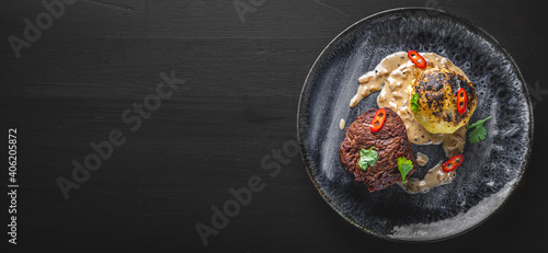 Grilled beef steak filet mignon with potato and sauce in plate on wooden table