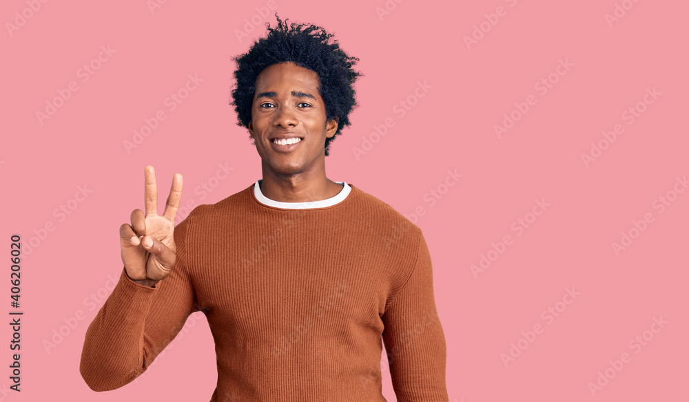 Handsome african american man with afro hair wearing casual clothes showing and pointing up with fingers number two while smiling confident and happy. Handsome african american man with afro hair wearing casual clothes showing and pointing up with fingers number two while smiling confident and happy.