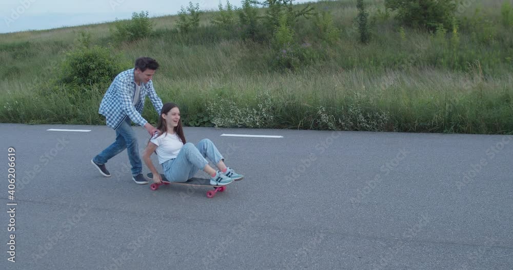Couple of teenagers having fun time during a skateboarding on road Couple of teenagers having fun time during a skateboarding on road