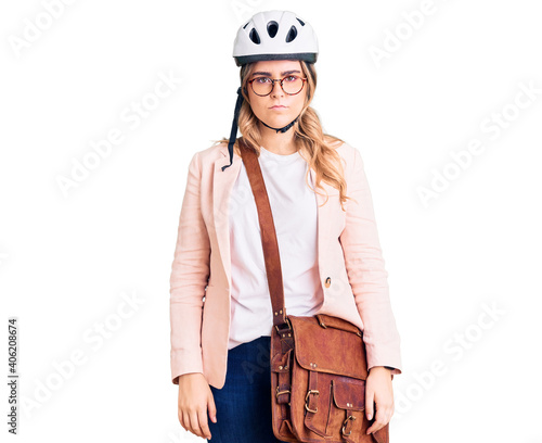 Young caucasian woman wearing bike helmet and leather bag with serious expression on face. simple and natural looking at the camera. © Krakenimages.com
