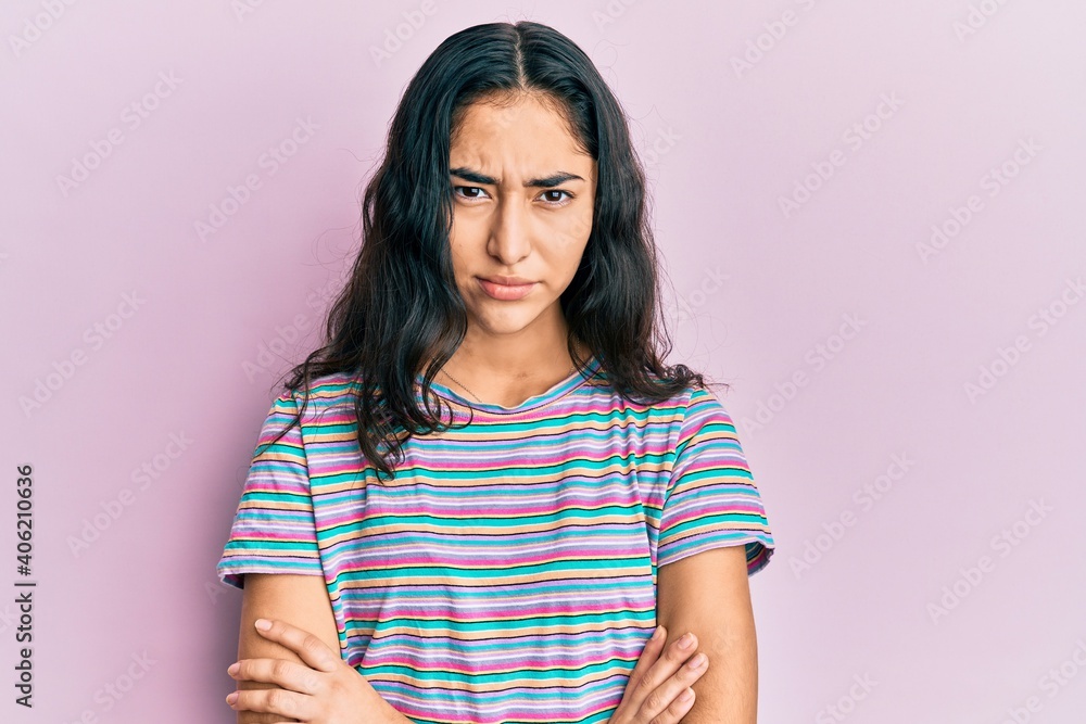 Hispanic teenager girl with dental braces wearing casual clothes skeptic and nervous, disapproving expression on face with crossed arms. negative person. Hispanic teenager girl with dental braces wearing casual clothes skeptic and nervous, disapproving expression on face with crossed arms. negative person.