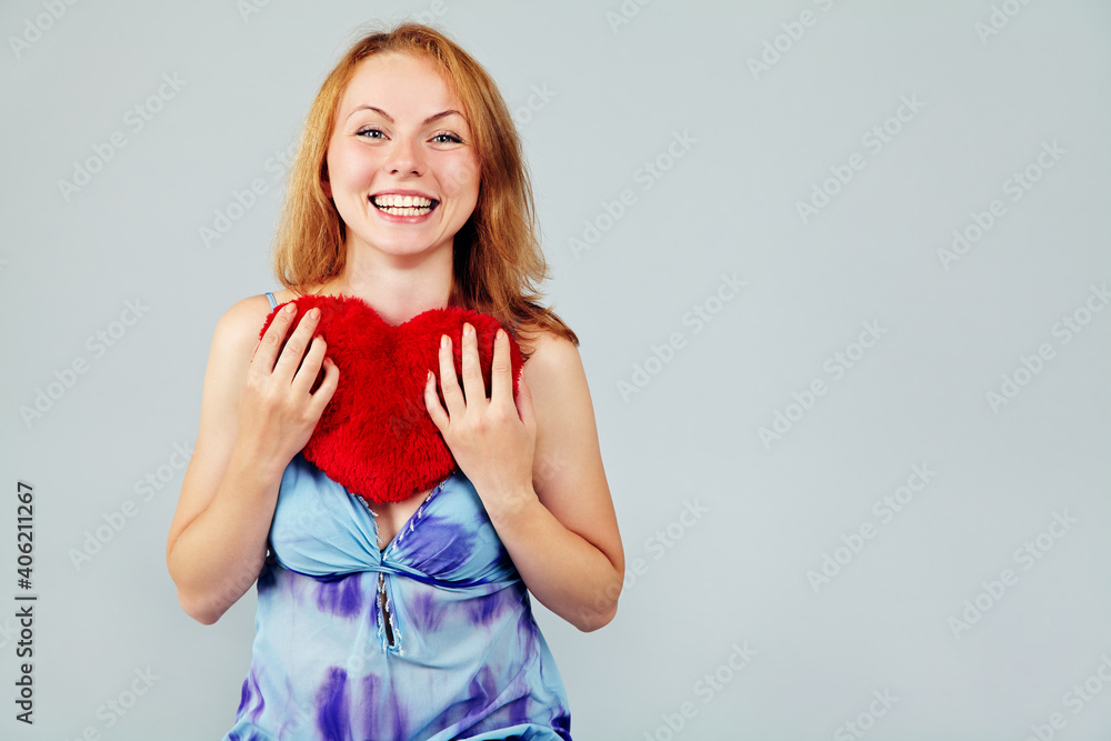 Pretty attractive blond woman holding a plush heart. waiting for Valentine's Day Pretty attractive blond woman holding a plush heart. waiting for Valentine's Day