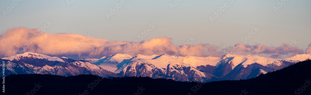 Stunning view of a snow capped mountain range during a beautiful sunset.