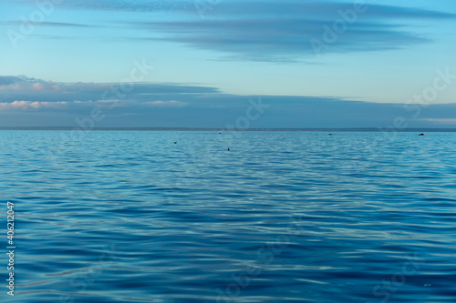 Turquoise water color against the sky. The Gulf of Finland. Baltic Sea. Ripples in the water. Sunny day. Background.