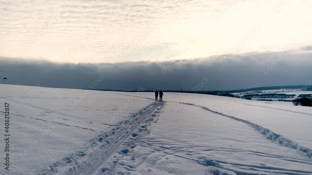 Couple is jogging as the exercise routine in the open field during a cold and snowy winter day. Couple is jogging as the exercise routine in the open field during a cold and snowy winter day.