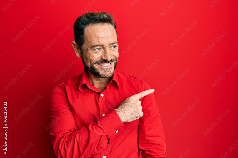 Middle age man wearing casual clothes smiling cheerful pointing with hand and finger up to the side
