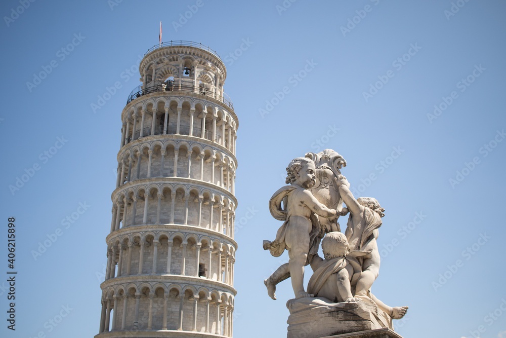 Leaning Tower of Pisa with statue angel at sunny day