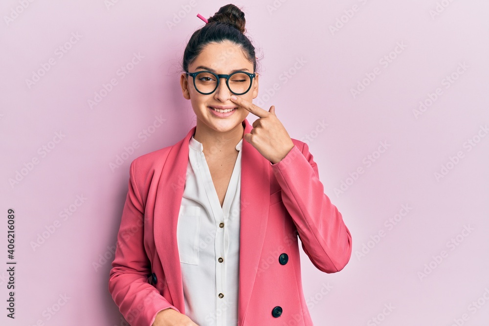 Beautiful middle eastern woman wearing business jacket and glasses pointing with hand finger to face and nose, smiling cheerful. beauty concept