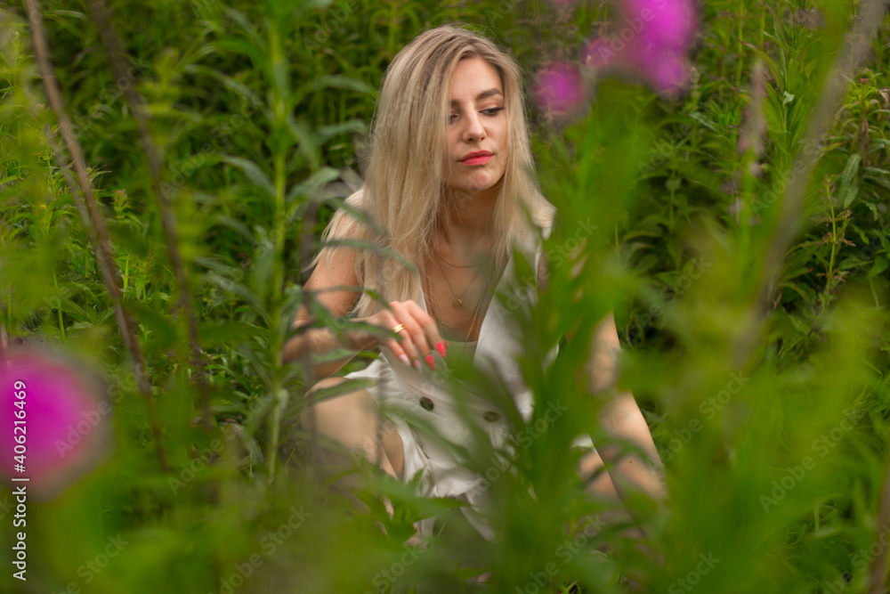 Sensual young woman, sitting on the grass in a field. High quality photo Sensual young woman, sitting on the grass in a field. High quality photo