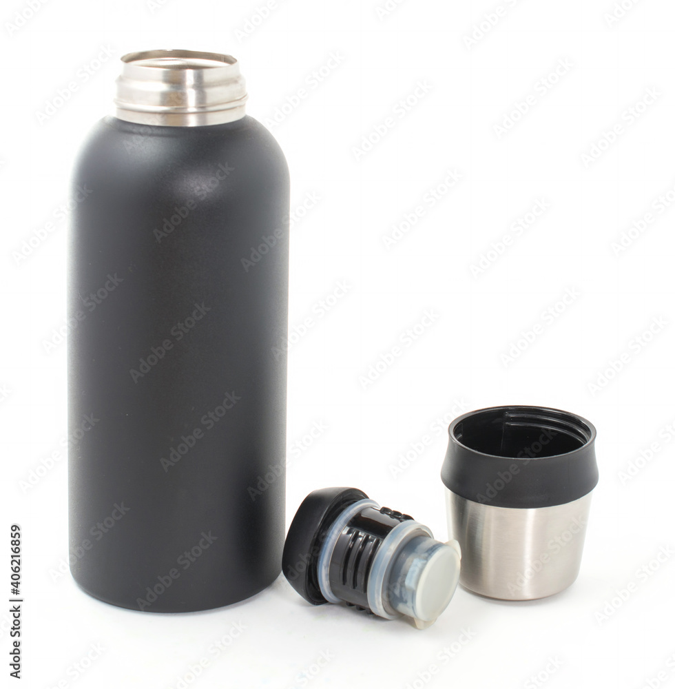 thermos with a dark texture and an open metal lid on the table. isolated on white background. travel and hiking, hot tea and coffee. thermos with a dark texture and an open metal lid on the table. isolated on white background. travel and hiking, hot tea and coffee.