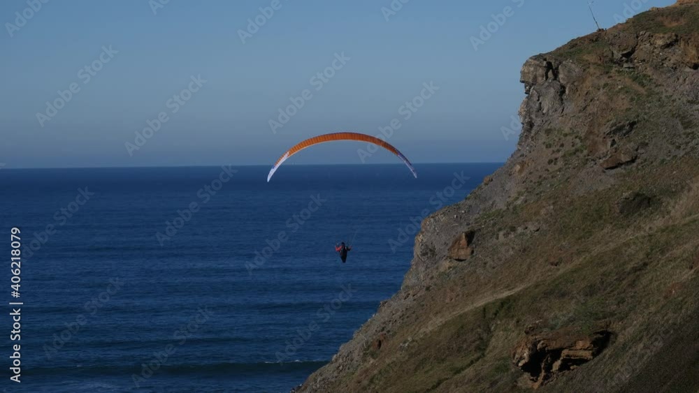 Paragliding flight on the coast between the sea and the cliffs. Concept feeling of freedom Paragliding flight on the coast between the sea and the cliffs. Concept feeling of freedom