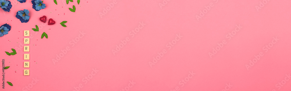 Spring beauty background, flat lay and top view on a vibrant pink with decorative flowers and lettering, copy space banner Spring beauty background, flat lay and top view on a vibrant pink with decorative flowers and lettering, copy space banner