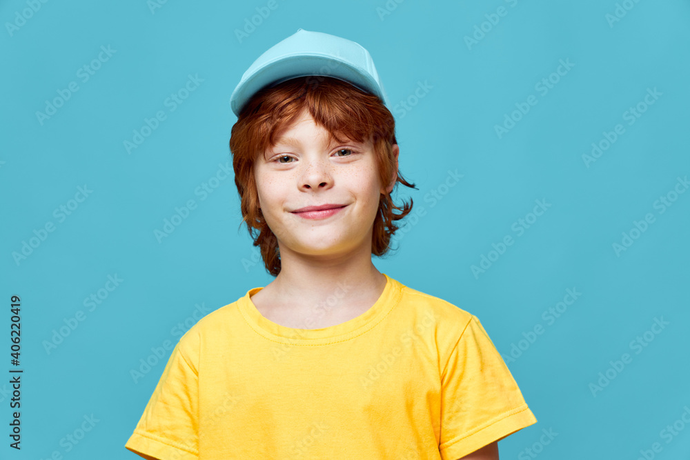 smiling redhead boy blue cap yellow tshirt cropped view 