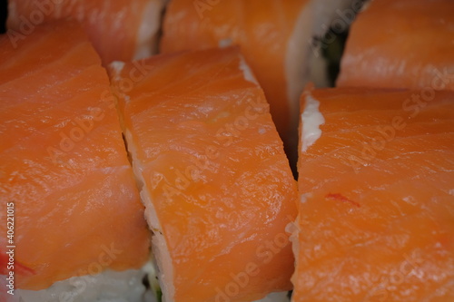 Macro of seafood. Rice rolls covered with pieces of salted salmon