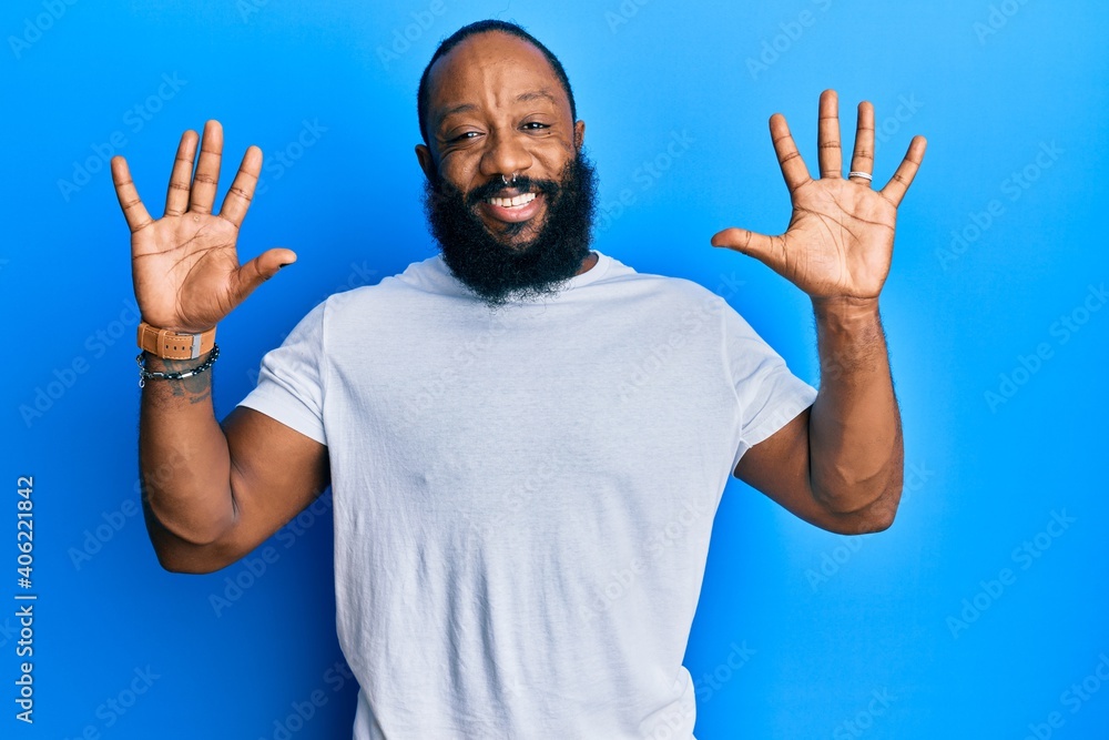 Young african american man wearing casual white tshirt showing and pointing up with fingers number ten while smiling confident and happy. Young african american man wearing casual white tshirt showing and pointing up with fingers number ten while smiling confident and happy.