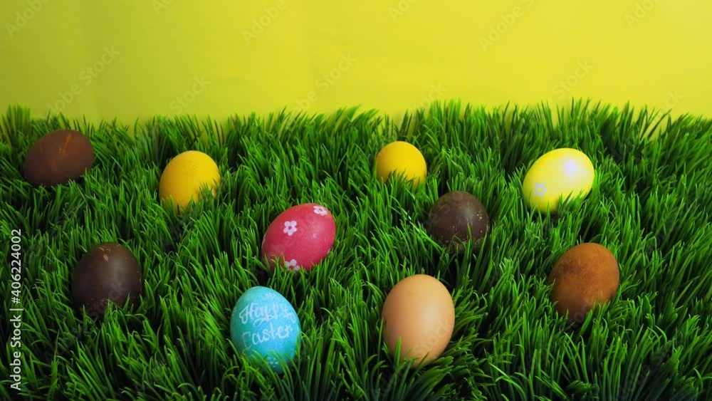 Happy Easter holiday concept stop motion animation. Colorful eggs appear on grass. Space for creative and design, copyspace, top view Happy Easter holiday concept stop motion animation. Colorful eggs appear on grass. Space for creative and design, copyspace, top view